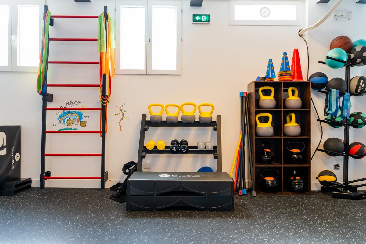 Wall bars, kettlebells and medicine balls used for active rehabilitation at Kinés Paris