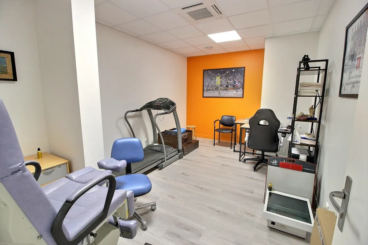 Salle de consultation du cabinet KinéO2 avec tapis de course et fauteuils de soin