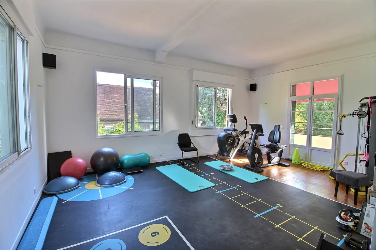 Salle d'exercices du cabinet Kinéau avec ballons, BOSU, tapis et vélos de rééducation